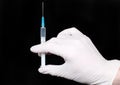 Syringe in medical gloves hand, injection. Royalty Free Stock Photo