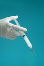 Syringe with medicine being held by hand with surgical glove. Royalty Free Stock Photo