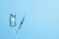 Syringe with medicine from glass vial on light blue background  flat lay. Vaccination against influenza  covid 19  measles Royalty Free Stock Photo