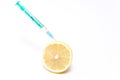 Syringe with medicine stuck in lemon. Concept of bio genetics research.