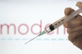 Syringe and Moderna logo on the background. Coronavirus, Covid-19 vaccine concept Royalty Free Stock Photo