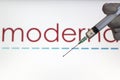 Syringe and Moderna logo on the background. Coronavirus, Covid-19 vaccine concept Royalty Free Stock Photo