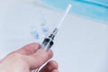 Syringe with needle covered in mans hand close up image