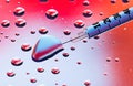 Syringe needle with fluid drops Royalty Free Stock Photo