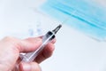 Syringe with needle in mans hand close up image