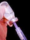 Syringe with needle prick and vaccine bottle vial doctor holding in gloved hand preparing dose injection shot jab closeup view Royalty Free Stock Photo