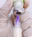 Syringe with needle prick and vaccine bottle vial held by a doctor nurse gloved hand injection shot jab closeup view image photo Royalty Free Stock Photo
