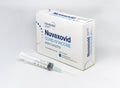 A syringe next to the Novavax Nuvaxovid Covid-19 vaccine box