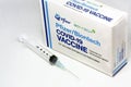 A syringe next to the Pfizer BioNTech Covid-19 vaccine box
