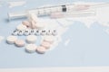 The word `pandemic` with medical syringes and pills,isolated over white