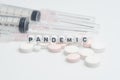 The word `pandemic` with medical syringes and pills,isolated over white