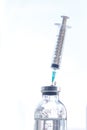 A syringe stuck in a saline bottle