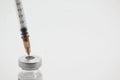 syringe stuck in vaccine vial on white background