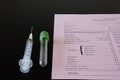 A syringe, testtube, and laboratory request