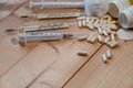 Syringes, thermometers and pills on a wooden table