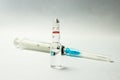 Syringe and transparent ampule on white