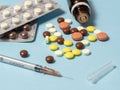 syringe and various medications, vitamins pills laid out on a background