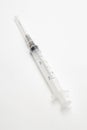 A syringe on a white surface. Royalty Free Stock Photo
