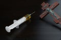 Syringe with Yellow Liquid And Crucified Jesus on Wooden Cross Royalty Free Stock Photo