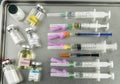 Syringes loaded with medication next to medicine vials prepared in hospital