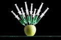 Syringes stuck in an apple Royalty Free Stock Photo