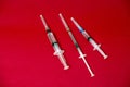 syringes with a transparent substance on a red background