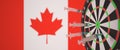 Syringes with a vaccine hit target near the Canadian flag. Successful medical research and vaccination in Canada