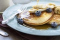 Syrup on blueberry banana pancakes on vintage plate. Royalty Free Stock Photo