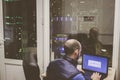 The system administrator with a laptop works in a modern data center. The duty engineer sits in a networked server room. Dispatch Royalty Free Stock Photo