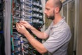 The system administrator works in the data center. Portrait of a technician working with computer equipment. Network engineer