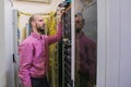 The system administrator works in the server room. The network engineer switches the wires in the data center. A young man is Royalty Free Stock Photo