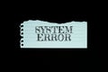 System Error text on paper torn top view on black background