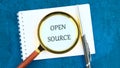 System and website builder concept. OPEN SOURCE in a clean notebook through a magnifying glass Royalty Free Stock Photo