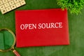 System and website builder concept. OPEN SOURCE on the cover of a red notebook on a green saturated background Royalty Free Stock Photo