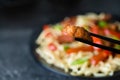 Szechuan stir fried spicy pork hold with chop sticks. Chinese food concept