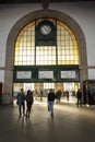 SÃÂ£o bento railway station illuminated by the warm light passing through the tall windows. People walking. Porto