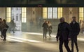 SÃÂ£o bento railway station illuminated by the warm light passing through the tall windows. People walking. Porto