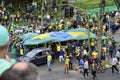 People carry the Brazilian flag across the asphalt to the crowd