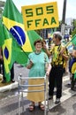 Lady with a walker and her patriotic husband with a sign written :`SOS FFAA` at the demonstration