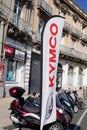Kymco brand text on flag street front of store scooter dealership manufacturer logo sign