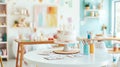 A pastel-themed art studio with a focus on a two-tiered frosted cake on a white stand Royalty Free Stock Photo