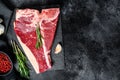 T bone steak. Organic raw Tbon beef. Black background. Top view. Copy space