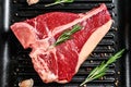 T bone steak in a pan. Organic raw Tbon beef. Black background. Top view