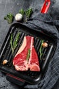 T bone steak in a pan. Organic raw Tbon beef. Black background. Top view