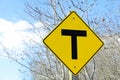 T crossing road sign along a country road