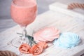 Fruit milkshake, sweet meringue desserts and tender flowers on a wooden coarse tray. light tender still life. summer snack