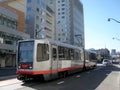 T Muni Light-rail train with ad on side on 4th street in Mission Bay Royalty Free Stock Photo