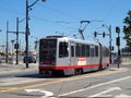 T Muni Light-rail train with ad on side on 4th street Royalty Free Stock Photo