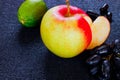 Fruit set. fresh lime, apple and grapes on a black surface.