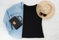 T shirt black. T-shirt Mockup flat lay with summer accessories. Hat, bag and sunglasses on wooden floor background. Copy space. Royalty Free Stock Photo